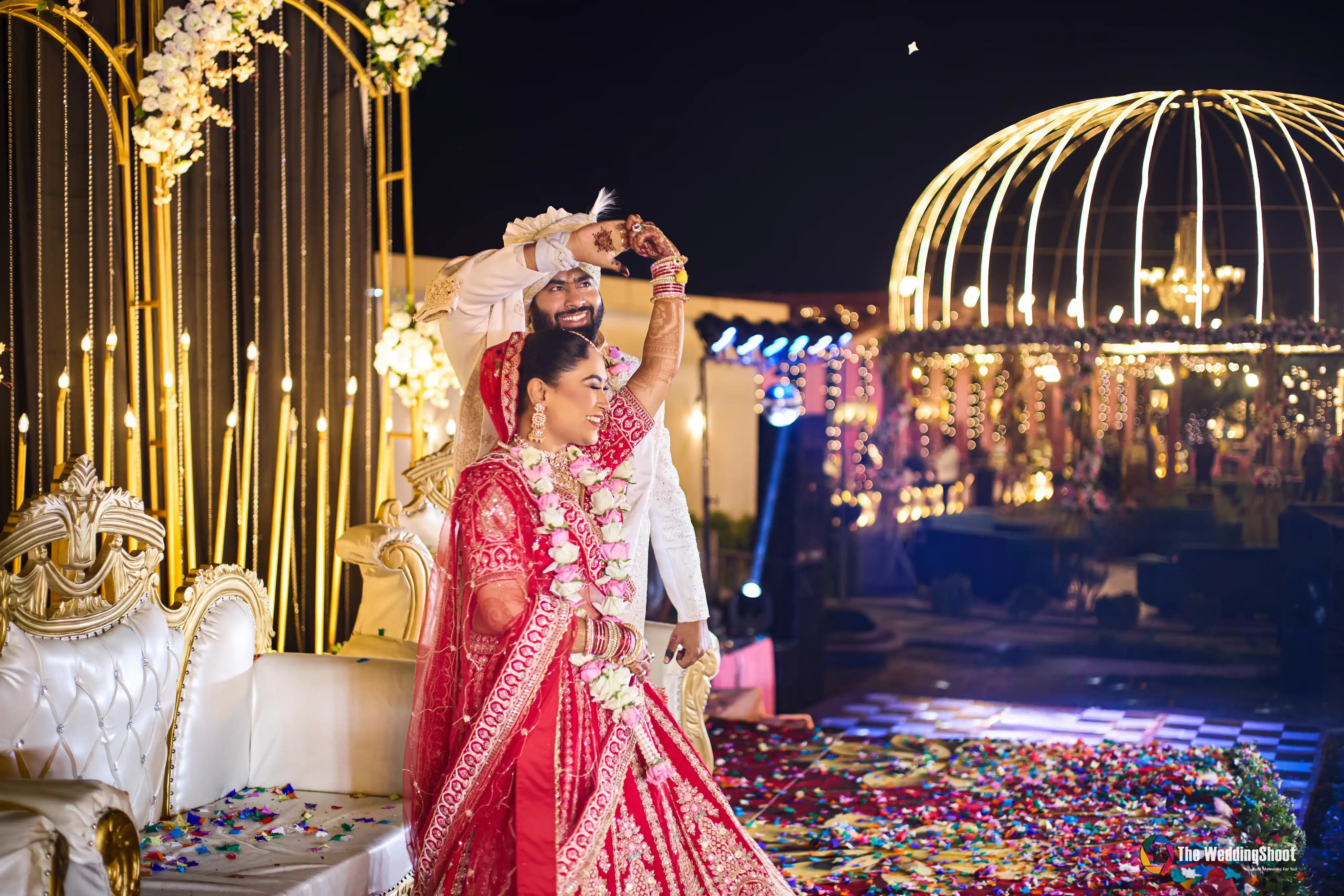 Wedding photography in Varanasi, bride and groom dancing on a lit stage at their reception, shot by The WeddingShoot